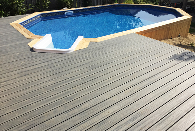 Custom composite grey deck surrounding pool.